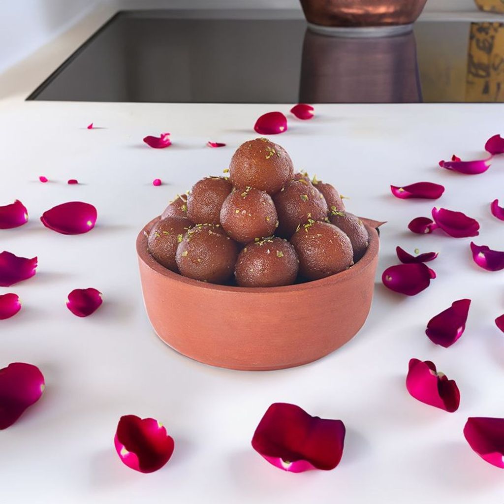 bowl of gulab jamuns besides rose petals