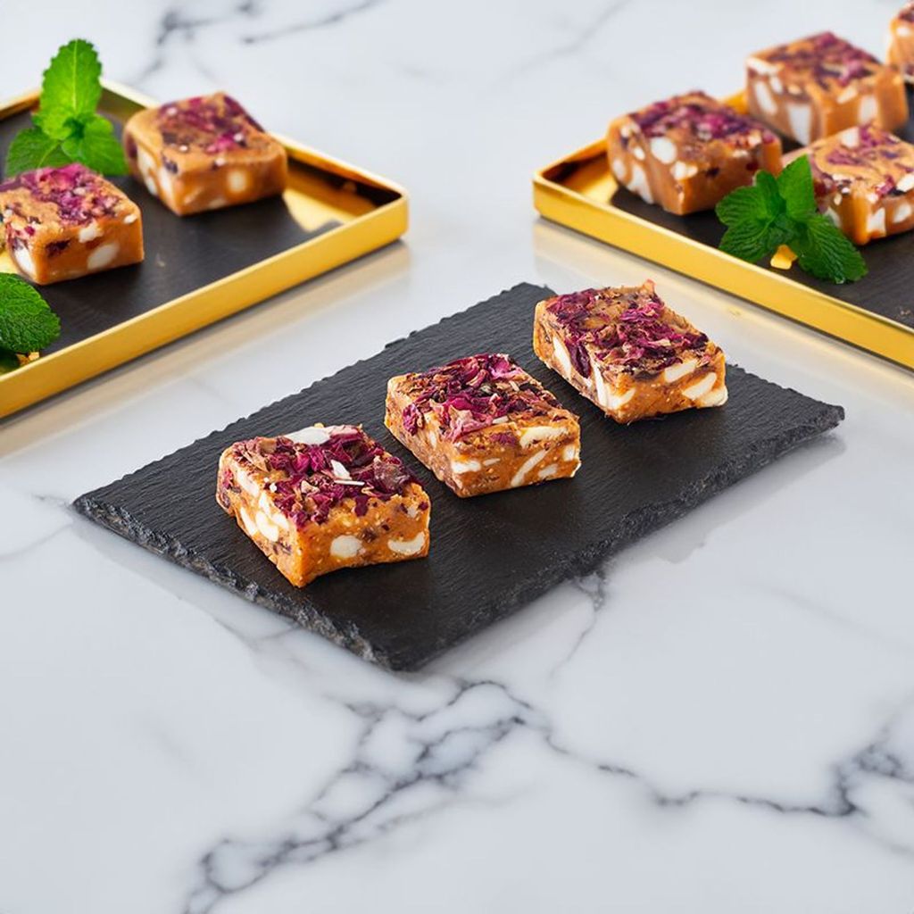 Anjeer Barfi dessert showcasing a rich, nutty, and fudgy Indian sweet garnished with chopped nuts.