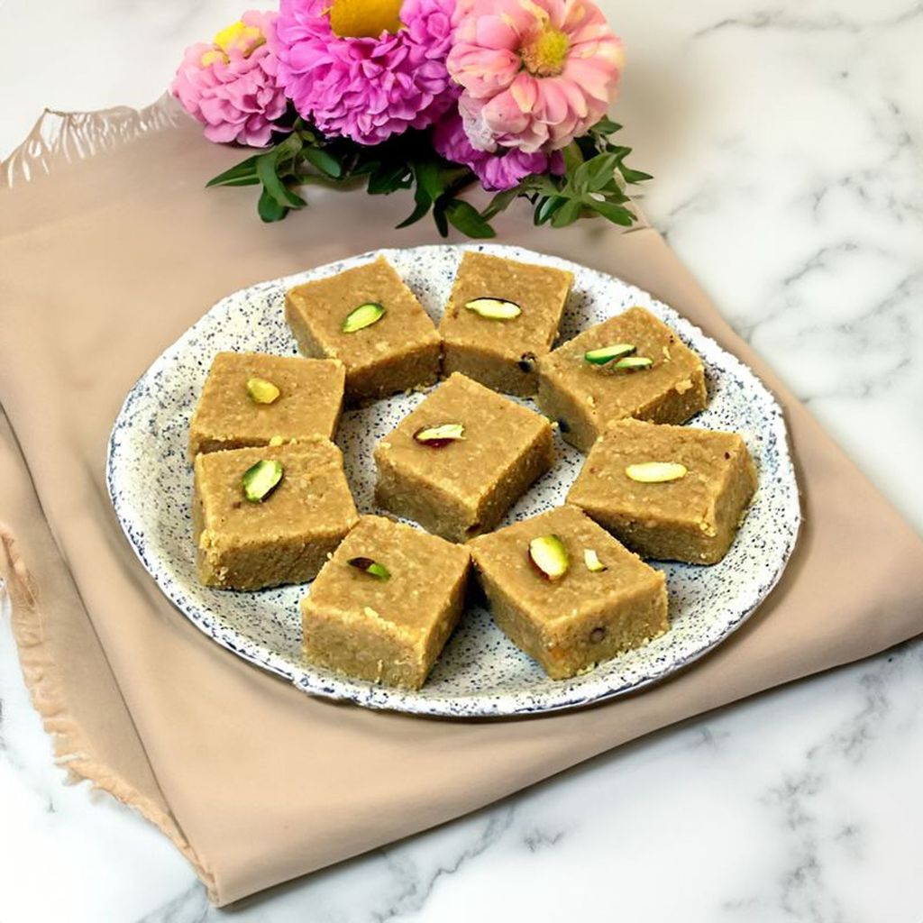 Chironji Barfi dessert showcasing a rich, nutty texture with a garnish of chironji seeds and chopped nuts.