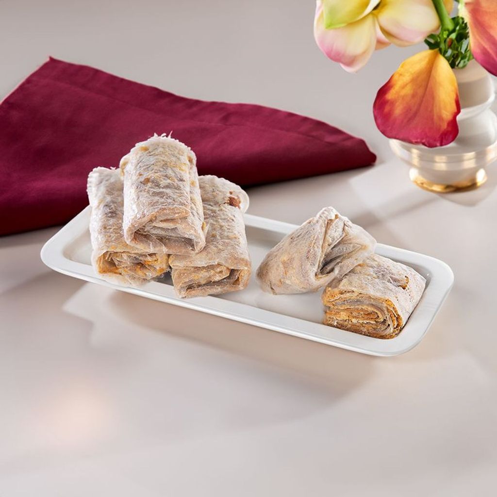 traditional andhra sweet bellam pootharekulu arranged on a white rectangular plate.