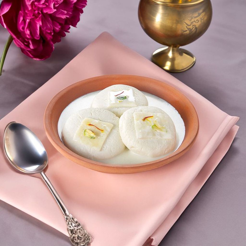 rasmalai served in a clay bowl with creamy milk and saffron