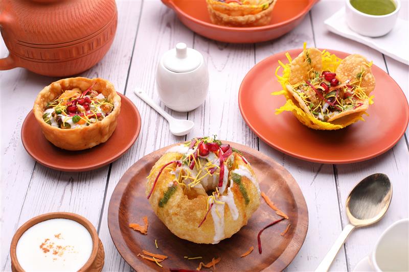 fried kachori with a side of rabdi on a wooden table