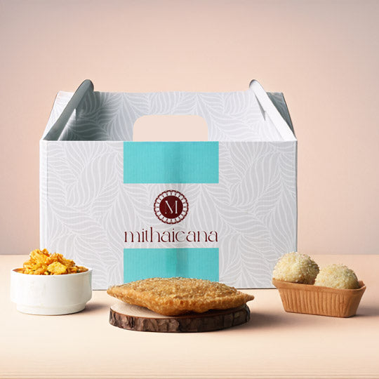 mithaicana snack box with sweets and savouries including ladoo, samosa, and chivda