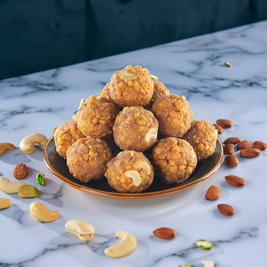 traditional indian sweet tirupati laddu stacked inside a plate.